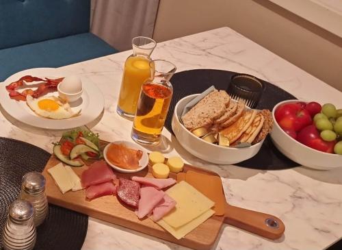 a table with a breakfast of cheese and meats and drinks at Hotell Regine in Bø