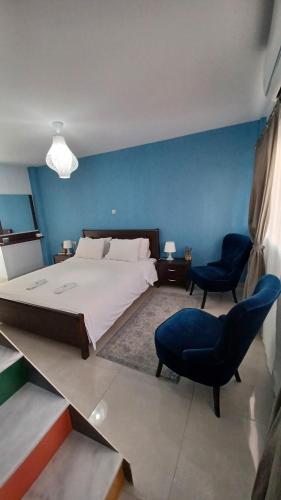 a bedroom with a large bed and a blue wall at Blue Studio in Nea Moudania