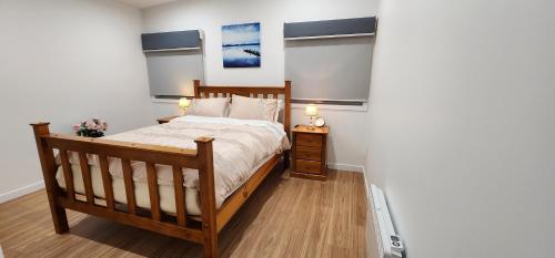 a bedroom with a bed and a night stand with two lamps at Beach Getaway - Blessington Villa in South Arm