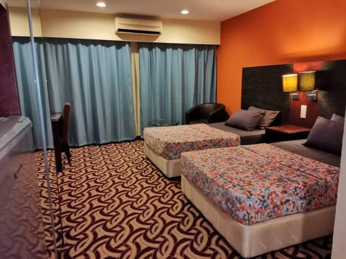 a hotel room with two beds and a couch at Stay In Kay Kay Hotel Suite at South China Sea Place Suite in Kota Kinabalu
