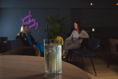 a glass of water on a table with a lemon slice at Farsund Fjordhotel in Farsund