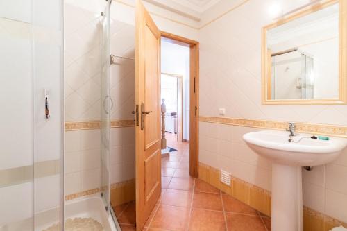 a bathroom with a sink and a shower at Moradia Rainbow by ALGARVEMANTA in Manta Rota
