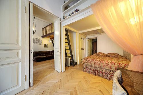 a bedroom with a bed and a staircase in a room at Apartment Bolshaya Morskaya in Saint Petersburg