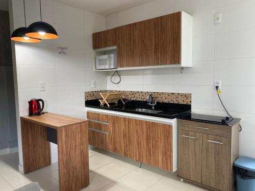 a kitchen with wooden cabinets and a counter top at Hotel APART Zuccolotto 202 in Aracruz