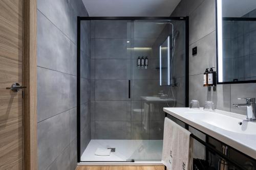 uma casa de banho com um chuveiro e um lavatório. em Petit Palace Cliper-Gran Vía em Madri