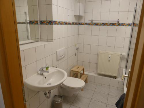 bagno con servizi igienici bianchi e lavandino di Jena City Apartment, sonnig, kostenloses Parken & Wifi a Jena