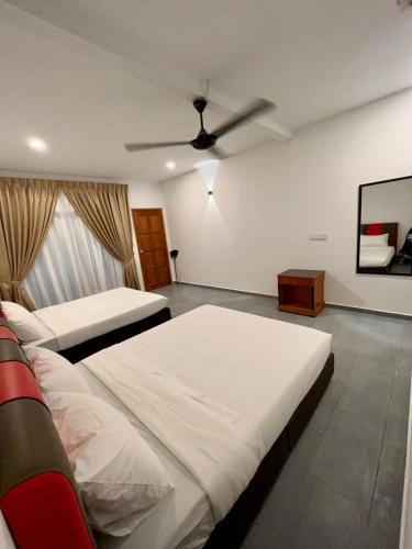 a bedroom with two beds and a ceiling fan at Dumba Bay Tioman in Tioman Island