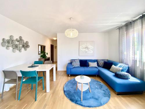 een woonkamer met een blauwe bank en een tafel bij Apartments Terra Solaris in Medulin