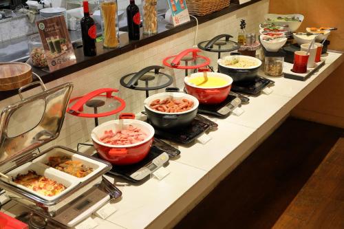 a counter with many pots and pans of food at Hotel Resol Trinity Sapporo in Sapporo