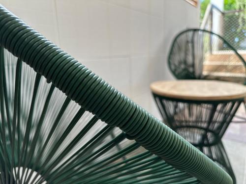 a green chair next to a table and a chair at Pousada Mawe in Paraty