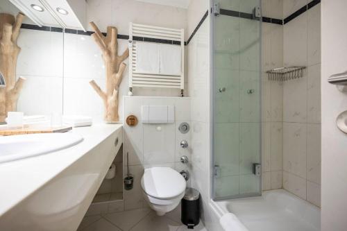 a bathroom with a toilet and a glass shower at Inselresidenz Strandburg - Ferienwohnung 210 (Ref. 50967u2) in Juist