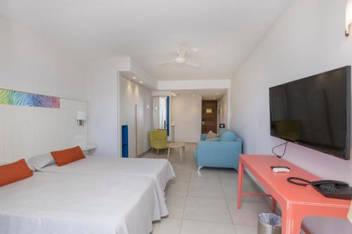 - une chambre avec un lit, une télévision et un canapé dans l'établissement Hotel LIVVO Veril Playa, à Playa del Ingles