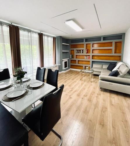 ein Wohnzimmer mit einem Tisch, Stühlen und einem Sofa in der Unterkunft Appartement 202 in Klagenfurt am Wörthersee