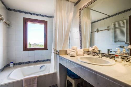 a bathroom with a sink and a tub and a mirror at Villa Zahara in Alcudia
