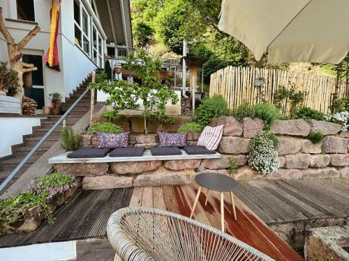 a garden with a bench and a stone wall at Ferienwohnung Silvi und Heinz Huber in Durbach