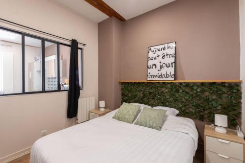 - une chambre avec un lit blanc et une fenêtre dans l'établissement Cabana & Le Petit Carnot - Centre-Ville, à Tournus