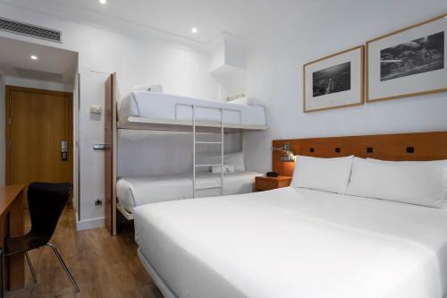 a bedroom with a large white bed and bunk beds at Petit Palace Cliper-Gran Vía in Madrid