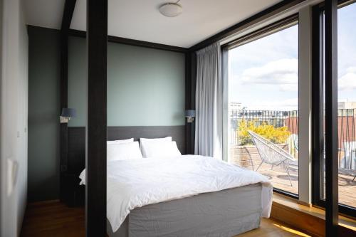 1 dormitorio con cama y ventana grande en Frogner House - Vika, en Oslo