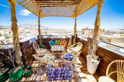 a balcony with chairs and a table on a roof at Riad Verus in Fès