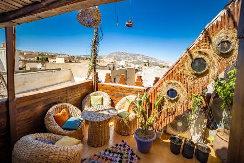 a balcony with wicker chairs and potted plants at Riad Verus in Fez