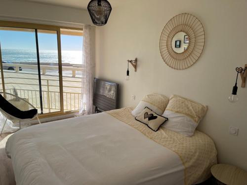une chambre avec un lit avec vue sur l'océan dans l'établissement Appartement Le Marbella, à Les Sables-dʼOlonne