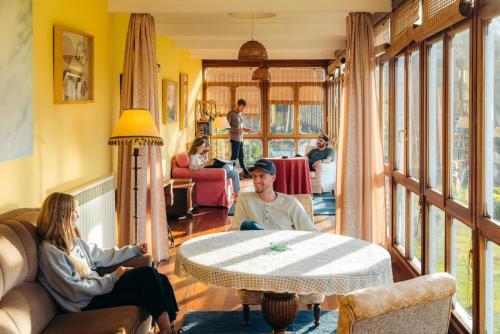 a group of people sitting in a living room at La Cochera de Somao, casona de tipología indiana in Somado