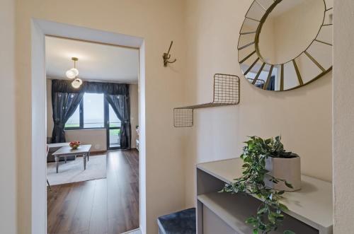 a hallway with a mirror and a living room at Апартаменти Ивайло / Ivaylo apartments in Burgas City