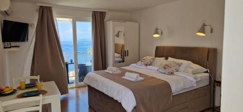 a bedroom with a large bed and a balcony at Apartmani Luan in Vis