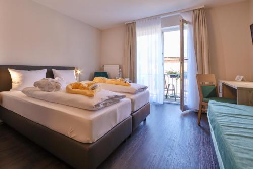 two beds in a hotel room with a balcony at Sonnenhotel Bayerischer Hof - All Inklusive Angebote verfügbar in Waldmünchen
