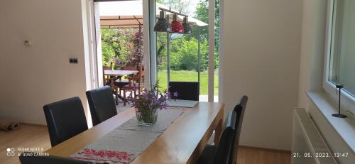 a dining room table with a vase of flowers on it at Villa FRIDA in Rogaška Slatina