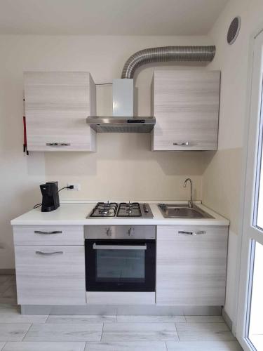 a kitchen with a stove and a sink at Civico 14 Apartment 3 in Monserrato