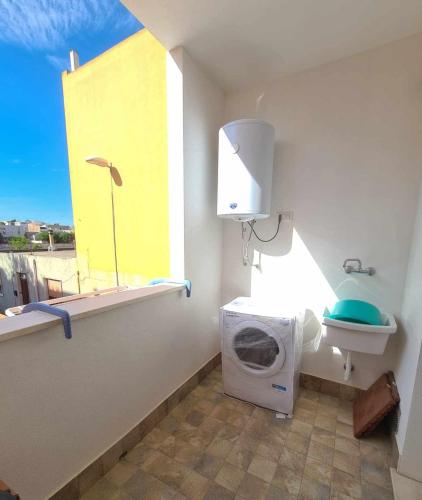 a bathroom with a washing machine and a window at Civico 14 Apartment 3 in Monserrato