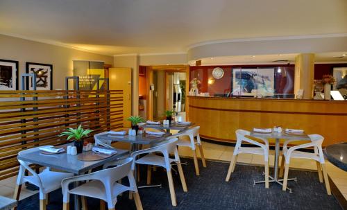 a dining room with tables and white chairs at Road Lodge JNB Airport in Johannesburg