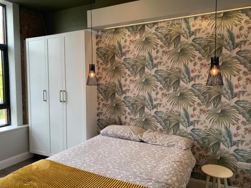 a bedroom with a bed with a floral wallpaper at Clanbrassill loft in Dundalk