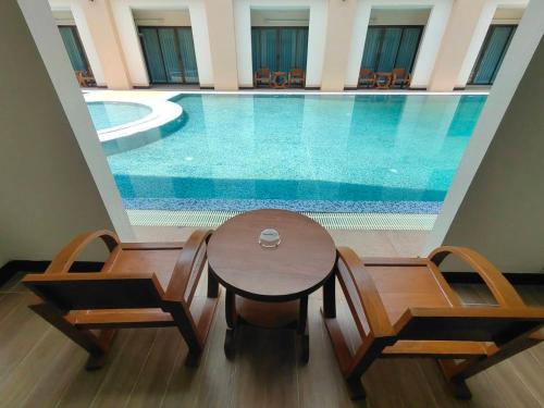 a swimming pool with a table and chairs next to it at Peacock De Pai Hotel in Pai