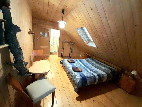 Zimmer mit einem Bett und einem Tisch in einer Hütte in der Unterkunft Pod Bieszczadem in Jaśliska