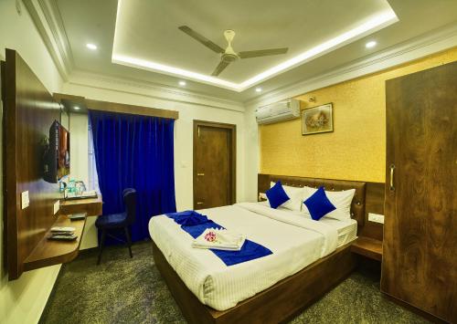 a hotel room with a bed and a desk and a bedroom at SM Royal Stay Hotel - Near Bangalore international Airport in Bangalore
