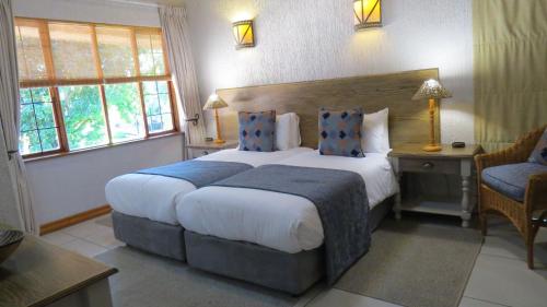 a hotel room with a large bed and a chair at Kruger Park Lodge - AM8 - 3 Bedroom Chalet in Hazyview