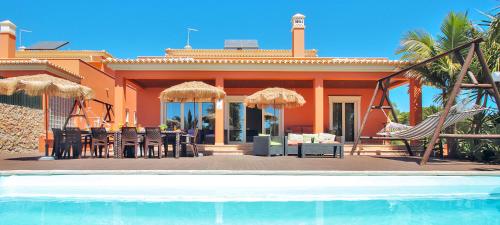 アルブフェイラにあるVilla California by Algarve Vacationのリゾートの隣にあるスイミングプール付きの家