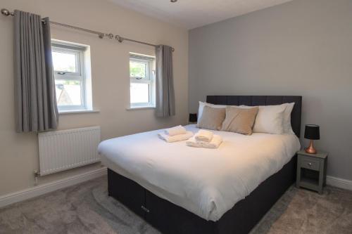 een slaapkamer met een groot bed en 2 handdoeken bij Beautiful townhouse in leafy suburb of Bradshaw in Bradshaw