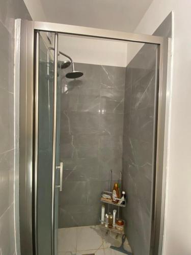 une douche avec une porte vitrée dans une salle de bain dans l'établissement Appartement ensoleillé, central et tout équipé avec vue Tour Eiffel et Panthéon, à Paris