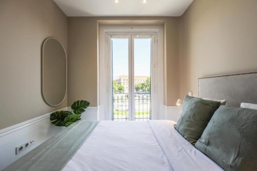 sypialnia z łóżkiem i dużym oknem w obiekcie Apartamento Embajadores XVII w Madrycie