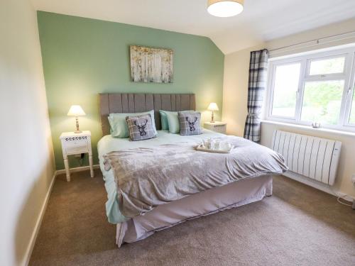 a bedroom with a large bed with green walls at 6 Hillside Cottages in Gainsborough