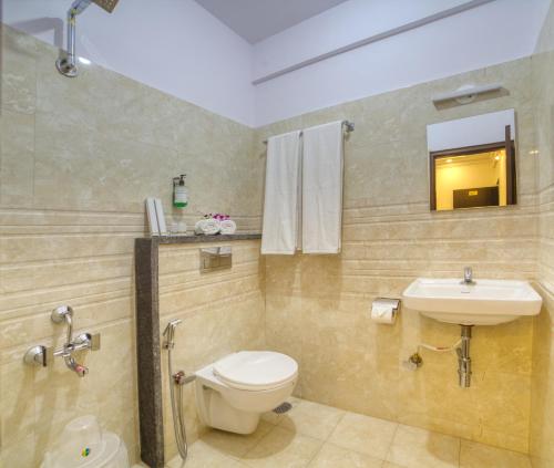 a bathroom with a toilet and a sink at SM Royal Stay Hotel - Near Bangalore international Airport in Bangalore