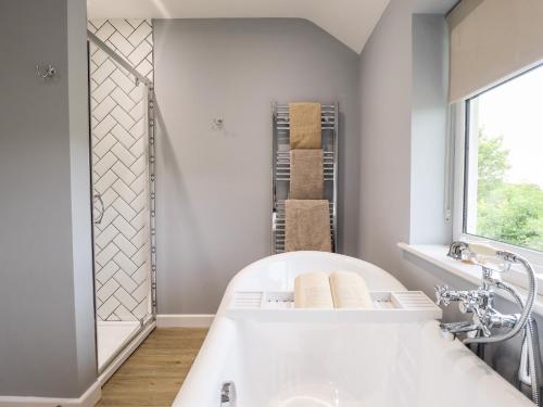 een badkamer met een wit bad en een raam bij 6 Hillside Cottages in Gainsborough