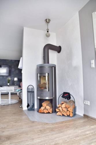a stove with a pile of logs in a room at Haffmuschel in Ueckermünde
