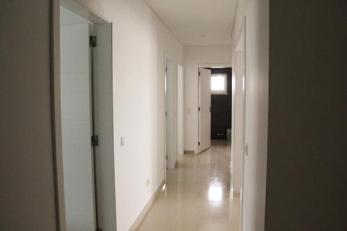 un pasillo vacío con paredes blancas y espejo en Gold Apartment Baleal, en Ferrel