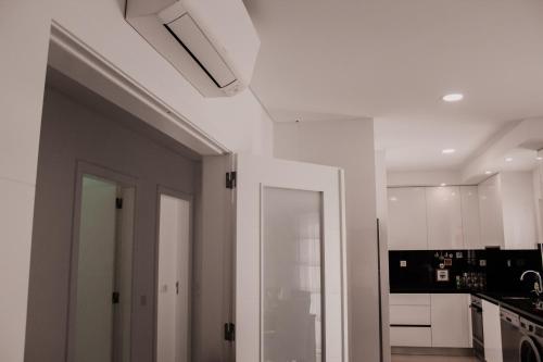 Una cocina con gabinetes blancos y una puerta blanca. en Gold Apartment Baleal, en Ferrel