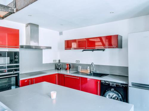 uma cozinha com armários vermelhos e uma máquina de lavar roupa em Loft Naturalia em Avignon