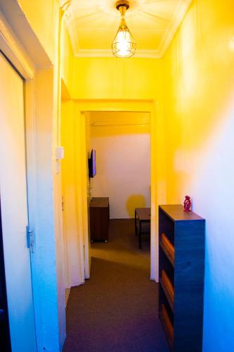 a hallway with a room with yellow walls and a dresser at One Bedroom House in Langata in Nairobi